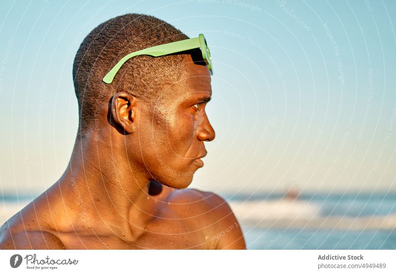 Ernster schwarzer Mann am Meer bei Sonnenuntergang MEER Strand Urlaub ernst Wochenende Wolkenloser Himmel Sonnenbrille Porträt männlich Afroamerikaner ethnisch