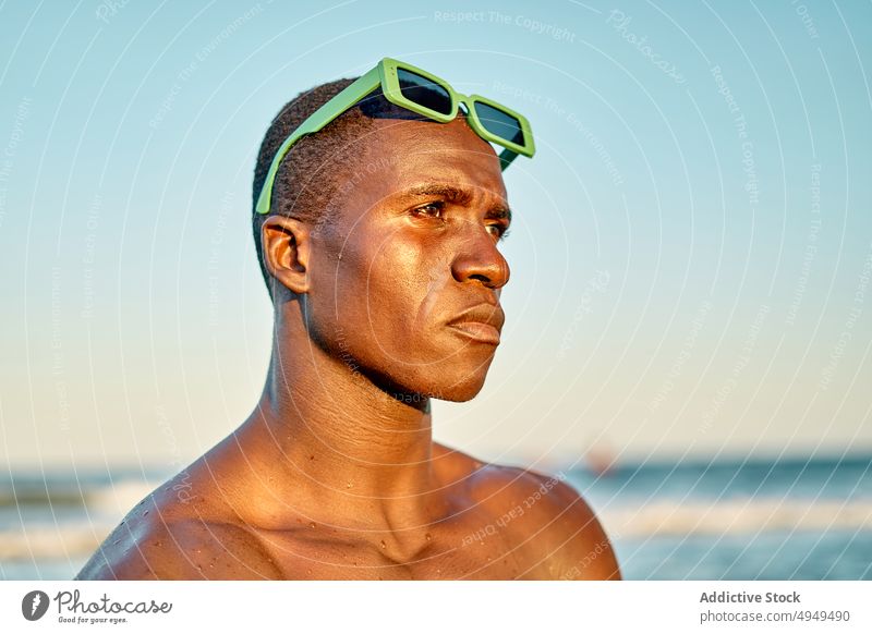 Ernster schwarzer Mann am Meer bei Sonnenuntergang MEER Strand Urlaub ernst Wochenende Wolkenloser Himmel Sonnenbrille Porträt männlich Afroamerikaner ethnisch