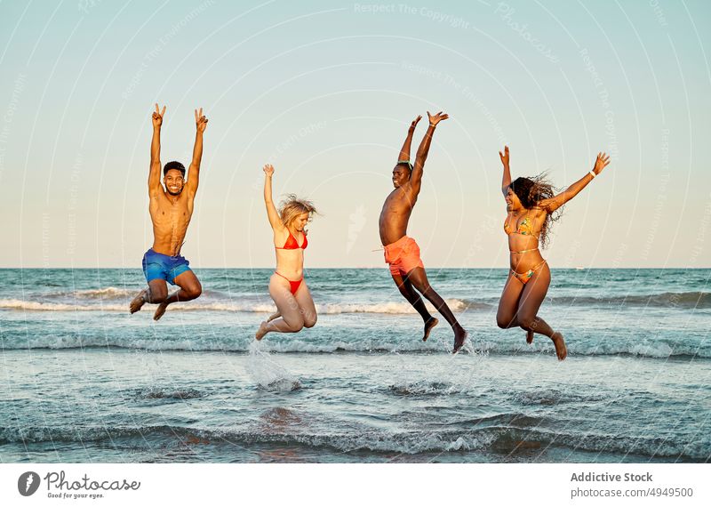 Verschiedene Freunde springen ins Meerwasser MEER winken Sonnenuntergang Energie Glück Zusammensein Wochenende Abend Männer Frauen Sommer heiter Freundin