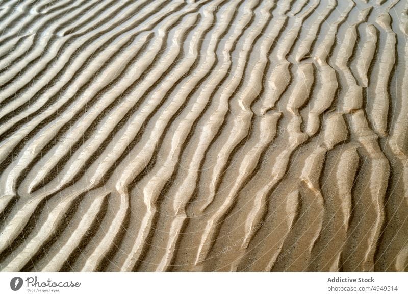 Gekräuselte Oberfläche von trockenem Sand Rippeln trocknen Textur Strand Sommer uneben rau Hintergrund Ufer winken Seeküste wüst Klima Dürre braun unfruchtbar