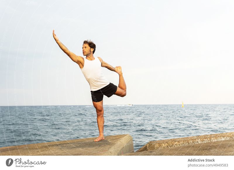 Älterer Mann in Natarajasan-Pose auf dem Damm Yoga Gleichgewicht MEER Borte Stauanlage Herr der Tanzpose üben Sommer Zen männlich tagsüber Wohlbefinden