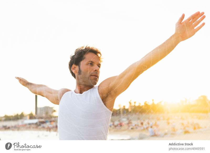 Mann streckt seinen Körper am Strand am Morgen Dehnung verdrehen Yoga Sitzung Sonnenaufgang üben Sommer männlich Wellness Gleichgewicht Energie Küste Vitalität