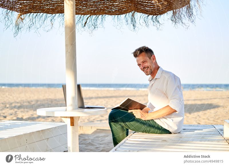 Geschäftsmann macht sich Notizen am Strand zur Kenntnis nehmen schreiben Hinweis Planer Telearbeit MEER Lächeln Business Projekt Daten Freude männlich