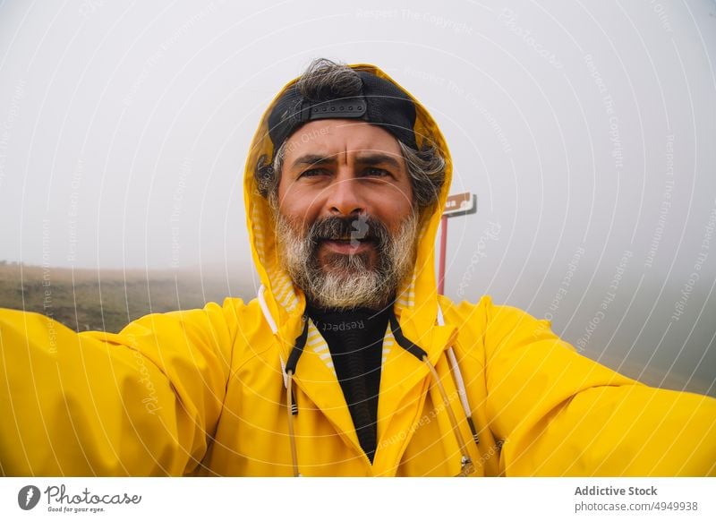 Mann mittleren Alters nimmt Selfie in nebligen Morgen Reisender Nebel Tal Ausflug Wochenende Natur Regenmantel Selbstportrait irati navarre Spanien männlich