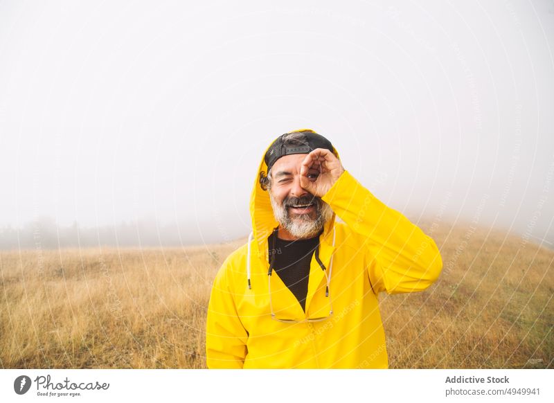 Älterer männlicher Reisender im nebligen Tal Mann Lächeln Fernglas gestikulieren Nebel Morgen Porträt Glück irati navarre Spanien Wanderung reif Lebensmitte