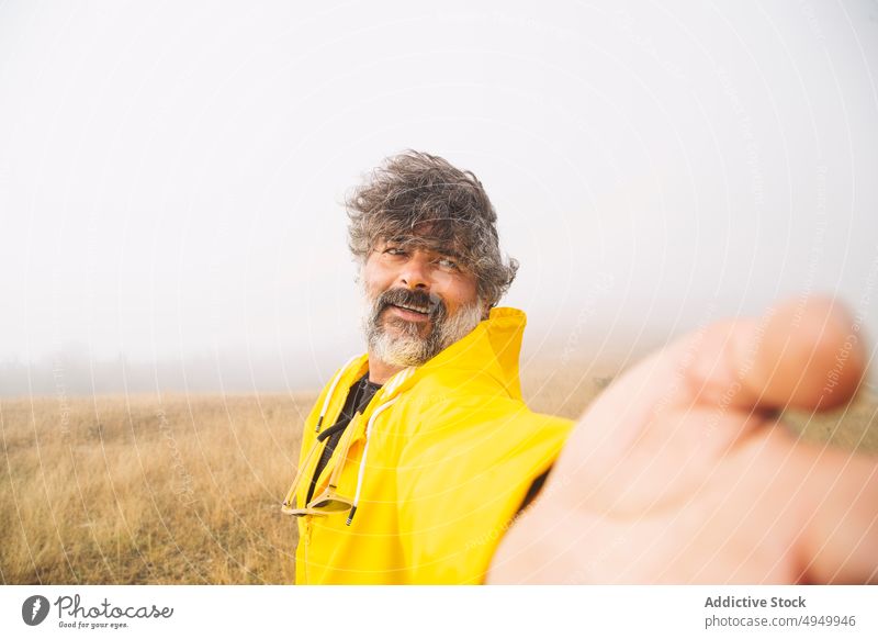 Glücklicher reifer Wanderer, der ein Selfie im nebligen Tal macht Mann Nebel Lächeln Morgen Wind sorgenfrei irati navarre Spanien männlich Lebensmitte