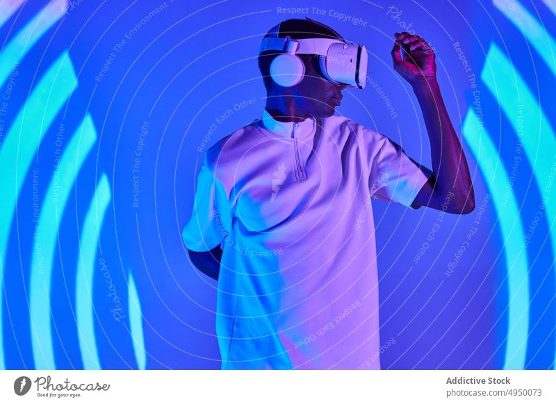Konzentrierter schwarzer Mann erlebt die virtuelle Realität Virtuelle Realität erkunden Imaginär Projektor unterhalten VR Cyberspace eintauchen Konzentration