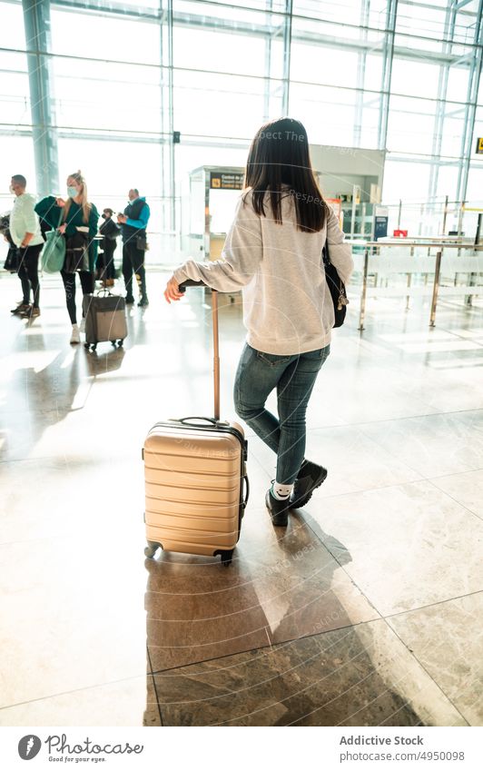 Anonyme Frau im Flughafenterminal Reisender Terminal Koffer fettarm warten Ausflug Passagier Abheben Gepäck Urlaub dunkles Haar Tourismus Tourist Tageslicht