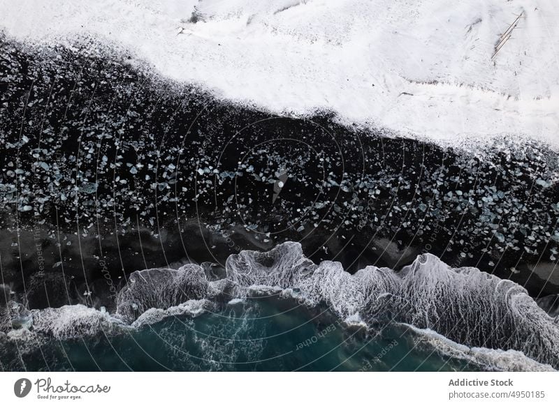 Meereswellen rollen an verschneites Ufer MEER winken kalt Schnee Felsen schäumen Wetter Unwetter Island Küste platschen Wasser Natur rau Klima Stein gefroren