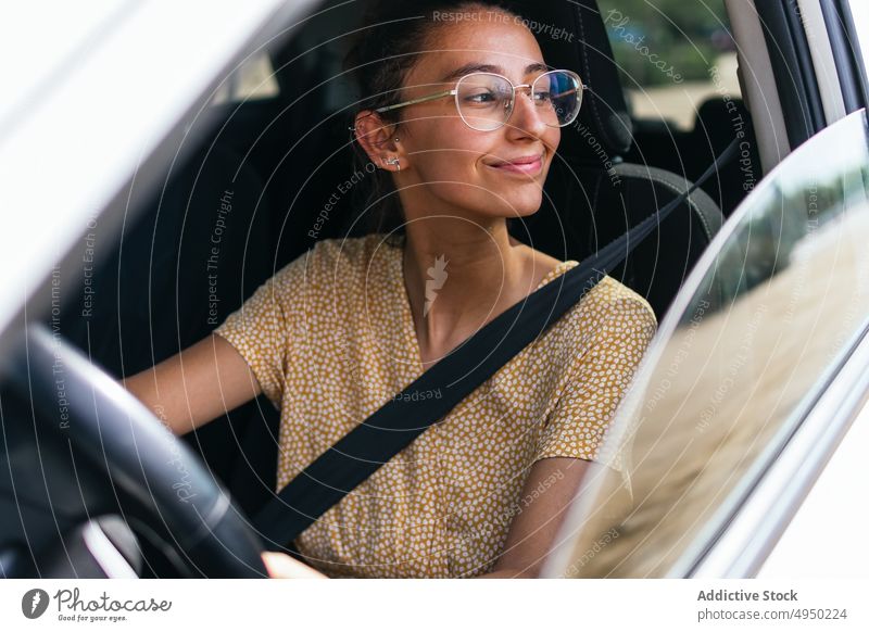 Junge Frau fährt modernes Auto Laufwerk PKW Autoreise Lenkrad Sommer Kontrolle Arbeitsweg lässig jung Fahrer Fahrzeug reisen Verkehr tagsüber Automobil Brille