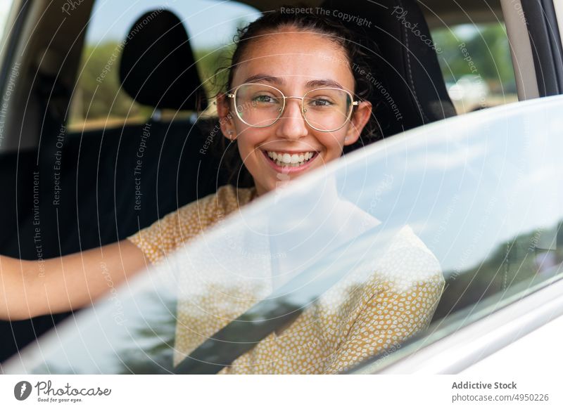 Junge lächelnde Frau am Steuer eines modernen Autos Laufwerk PKW Autoreise Lenkrad Sommer Kontrolle Arbeitsweg lässig jung Fahrer Fahrzeug reisen Verkehr