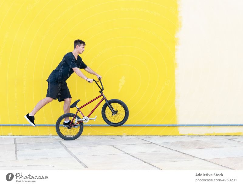 Mann mit BMX-Rad läuft auf Mauer Spaziergang Wand Fahrrad bmx Trick Straße urban Bürgersteig Hobby männlich Radfahrer lässig Aktivität Fahrzeug Bewegung