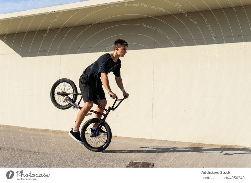 Mann mit BMX-Rad in der Nähe an der Wand Fahrrad bmx Trick Straße urban Bürgersteig Hobby männlich Radfahrer lässig Aktivität Fahrzeug Bewegung tagsüber