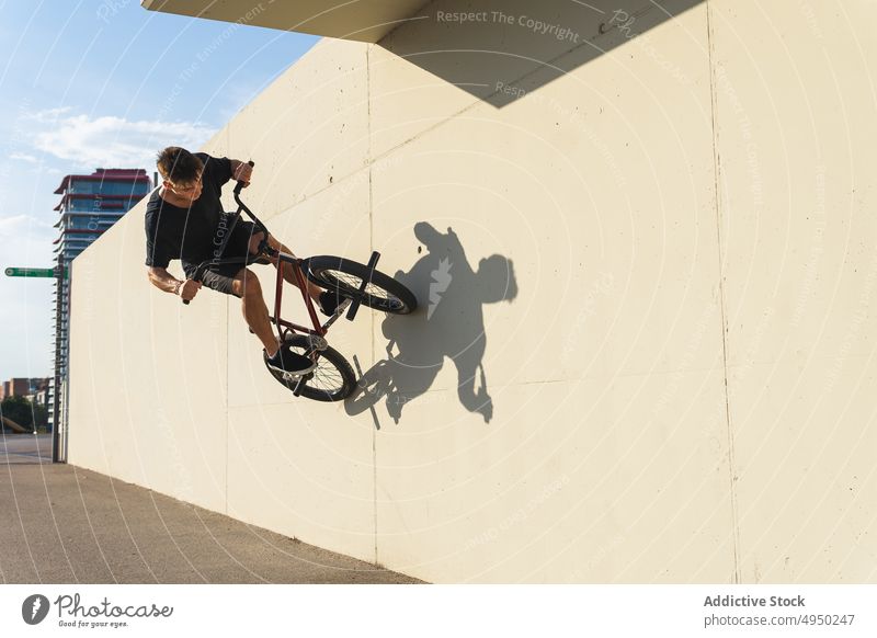 Junger Mann macht Wallride-Trick auf BMX-Rad bmx Fahrrad Skateplatz urban Straße Mitfahrgelegenheit Wand männlich jung Stunt Energie üben Radfahrer Hobby
