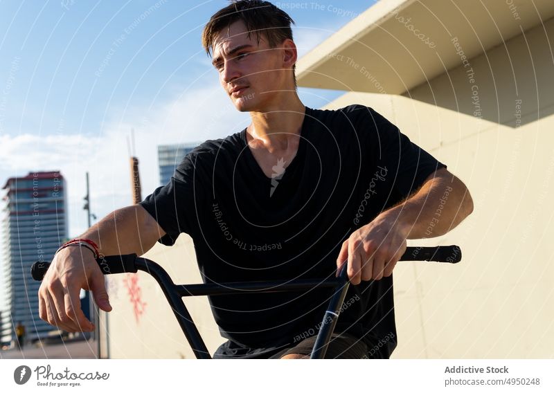 Junger Mann mit Fahrrad im Skatepark Skateplatz Wand Hobby Wochenende Pause tagsüber modern urban männlich jung lässig T-Shirt Sommer Lenker berühren pausieren
