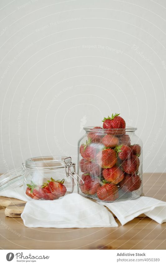 Glasgefäß mit frischen Erdbeeren auf Holztisch Beeren Küche Lebensmittel gesunde Ernährung Vitamin roh Schneidebrett ganz reif lecker Bestandteil Frucht