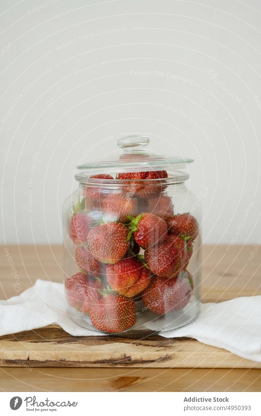 Glasgefäß mit frischen Erdbeeren auf Holztisch Beeren Küche Lebensmittel gesunde Ernährung Vitamin roh Schneidebrett ganz reif lecker Bestandteil Frucht