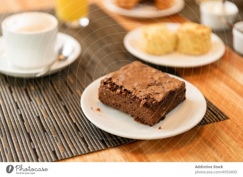 Teller mit Brownie auf dem Kaffeetisch Frühstück Dessert dienen Tisch Café Schokolade Lebensmittel süß Latte syrniki Zusammensetzung Morgen frisch Gastronomie