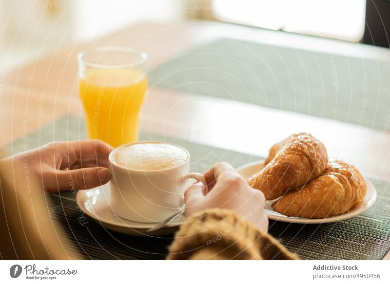 Anonyme Frau beim Frühstück im Restaurant Kaffee Saft Croissant Tisch Getränk Wochenende lässig Pullover Café Kantine Lifestyle Kaffeehaus sitzen Freizeit