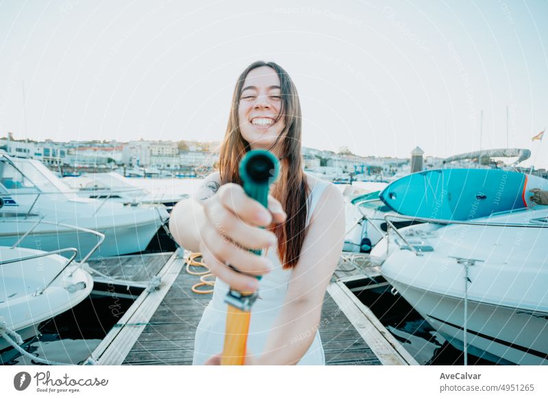 Eine junge, fröhliche Frau reinigt eine klassische Segelyacht mit Süßwasser nach dem Segeln im Mittelmeer. Luxusreisen und Lifestyle-Konzept. Schiff Verkehr
