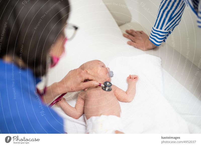 Ein Baby liegt auf dem Rücken, während sein Arzt es bei einer Standarduntersuchung untersucht. Säugling Junge Kinderärztin Stethoskop Herzschlag Kindheit