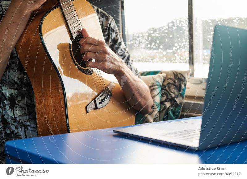 Mann spielt Gitarre und beobachtet Online-Tutorial spielen online Laptop Kleintransporter lernen Lektion Gitarrenspieler männlich akustisch Musiker Melodie