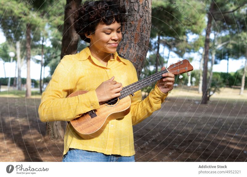 Charmante junge Frau spielt Ukulele im Park Musik spielen träumen Inhalt farbenfroh Sommer charmant Teenager Instrument Gitarre akustisch Musiker Melodie Gesang