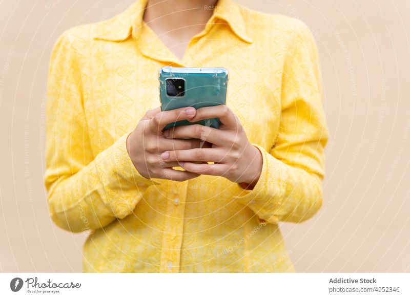 Inhalt ethnische Frau in hellem Hemd mit Smartphone urban farbenfroh modern lässig Telefon Browsen benutzend Kommunizieren Mobile App Nachricht Texten Apparatur