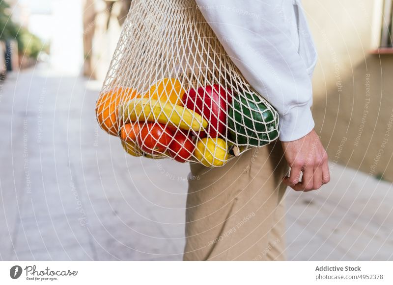 Anonymer Mann mit Obst im Netzbeutel in der Stadt ineinander greifen Tasche umweltfreundlich Frucht Straße Lebensmittelgeschäft Öko natürlich