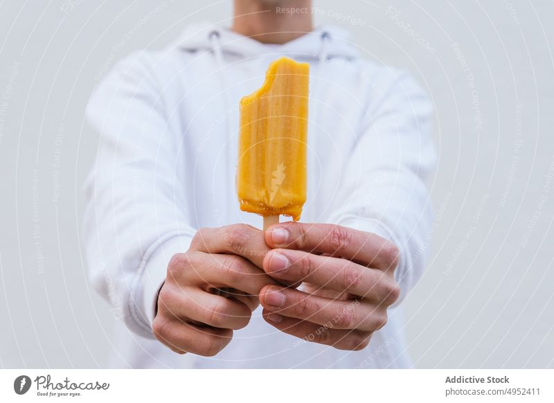 Anonymer Mann mit Natureislutscher schaut in die Kamera Eis Kies Speiseeis kalt natürlich gefroren Leckerbissen süß männlich aktualisieren geschmackvoll Dessert