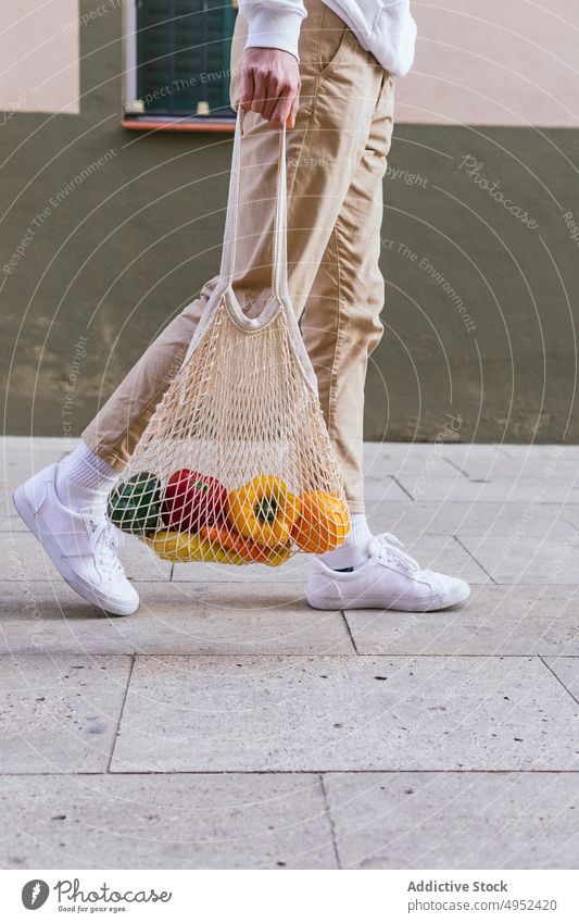 Anonymer Mann mit Obst im Netzbeutel in der Stadt ineinander greifen Tasche umweltfreundlich Frucht Straße Lebensmittelgeschäft Öko natürlich