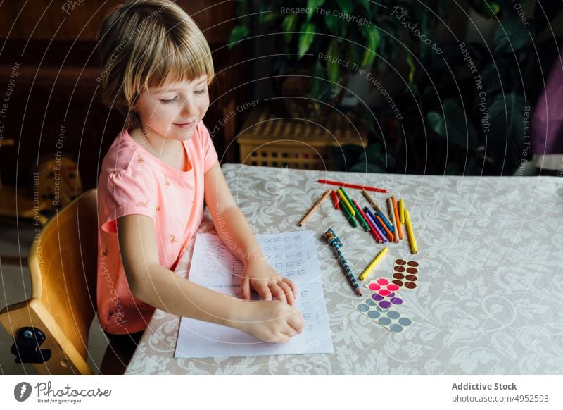 Niedliches kleines Mädchen bei den Hausaufgaben Kind im Innenbereich sitzen schön Bildung Tisch allein Aufmerksamkeit Schlafzimmer Buch lässig Kaukasier Tochter