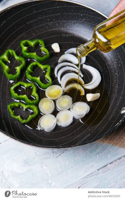 Öl von Hand in einen Topf mit Gemüse gießen Lebensmittel Essen zubereiten Erdöl Gesundheit Vorbereitung Mahlzeit anonym Hintergrund Küchenchef Konzept Kocher