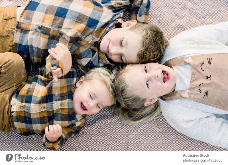 Niedliche positive kleine Geschwister auf Decke liegend im Tageslicht Kinder Lügen Picknick Geschwisterkind Bruder Schwester Zusammensein Zeit verbringen gleich