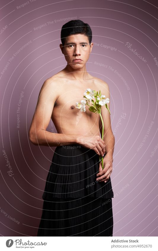 Romantischer Schwuler mit blühendem Blumenstrauß auf zerknittertem Tuch schwul ohne Hemd romantisch lgbt akzeptieren Mann natürlich Porträt Stiefel Rock Gewebe