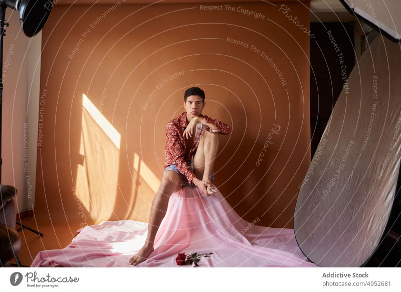 Gay auf zerknittertem Stoff im Fotostudio Model lgbt feminin Stil Tastfuß romantisch akzeptieren Mann Atelier Porträt Individualität Blume gefaltet Gewebe Licht