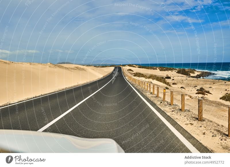 Straße und Meer auf den Kanarischen Inseln Kanarische Inseln Zaun Küste Wasser Uferlinie Sand Steine Fuerteventura Landschaft Natur reisen Blauer Himmel Bank