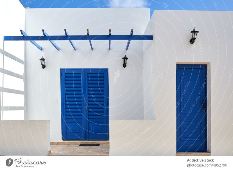 Weißes Häuschen mit hellblauen Türen an einem sonnigen Tag Haus Außenseite weiß Architektur typisch Cottage wohnbedingt Konstruktion verweilen Anwesen