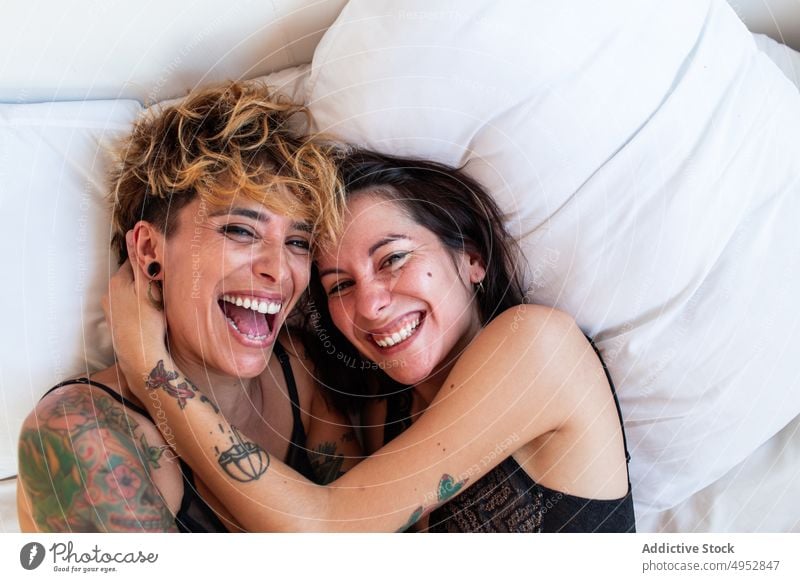 Lesbisches Paar hat Spaß im Bett lesbisch Kribbeln Lachen heimwärts Zusammensein Partnerschaft Liebe Frauen Schlafzimmer lgbt romantisch Homosexualität sinnlich