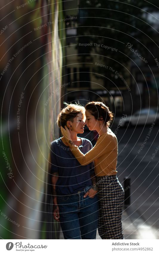 Lesbisches Paar steht in einer Graffiti-Wand auf der Straße lesbisch Zaun Termin & Datum Frauen Liebe lgbt Freiheit Homosexualität Rechte Stolz romantisch