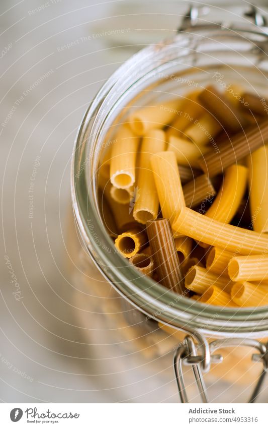 Glas voll mit Makkaroni Spätzle ungekocht roh Lebensmittel Italienisch Küche Container Bestandteil trocknen gelb Gesundheit traditionell Essen zubereiten