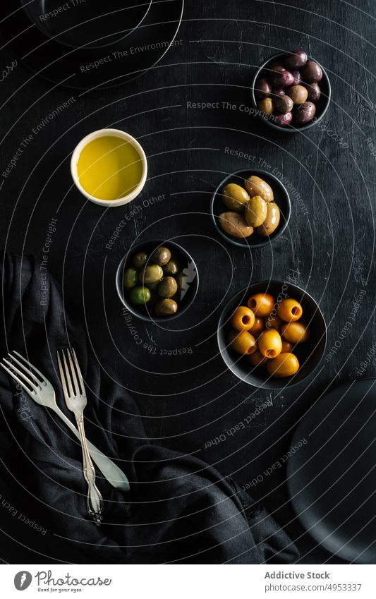 Sortiment von Oliven in eleganter schwarzer Dekoration auf dem Tisch Varieté oliv Schalen & Schüsseln Erdöl Gesundheit Mahlzeit Feinschmecker traditionell