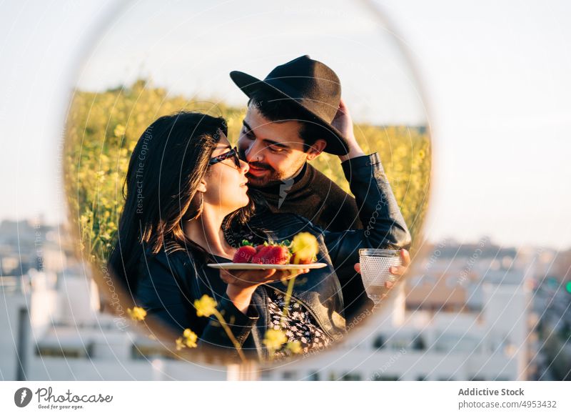 Ethnisches Paar mit Erdbeeren, die sich im Spiegel in der Stadt spiegeln Freund Freundin Reflexion & Spiegelung Partnerschaft Liebe verträumt Großstadt Wiese