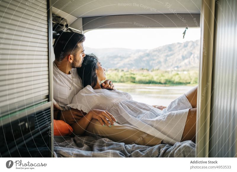 Liebendes ethnisches Paar von Reisenden im Van liegend reisen Kleintransporter Lügen Bett Reisender Wohnwagen Zusammensein Wohnmobil Angebot hispanisch