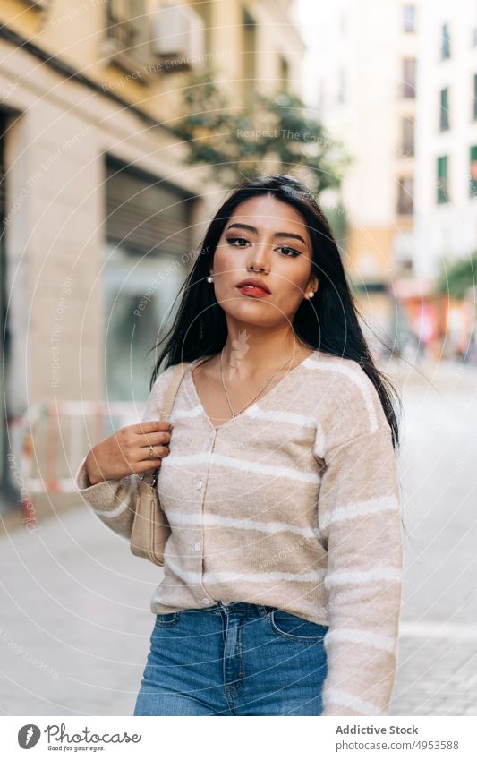 Asiatische Frau in legerer Kleidung auf städtischem Bürgersteig feminin Angebot charmant freundlich angenehm lässig Stil Laufsteg Porträt Handtasche Accessoire
