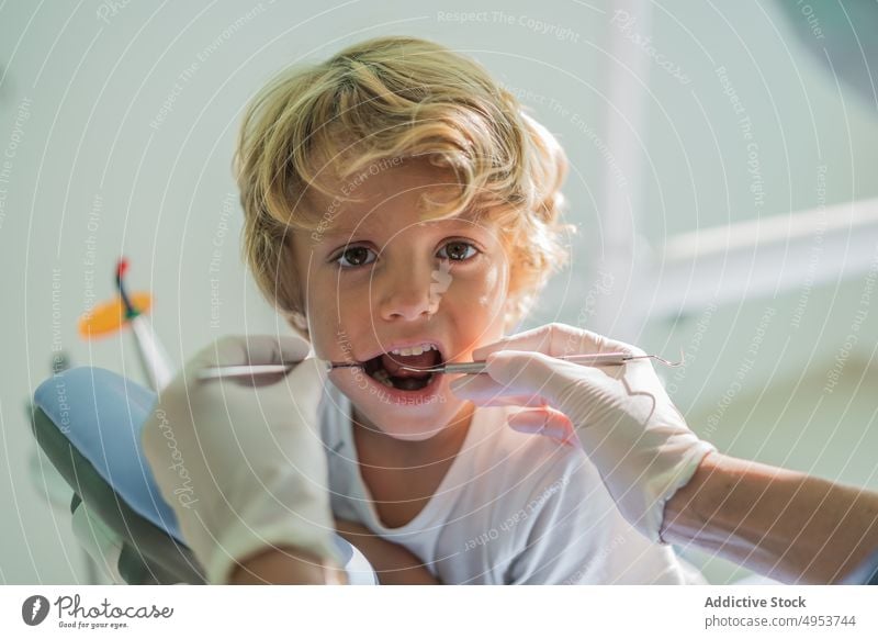 Crop-Zahnarzt kontrolliert Zähne eines Jungen geduldig Check-up Klinik Werkzeug dental Medizin Gesundheitswesen Verfahren Handschuh Kind Hygiene mündlich Kur