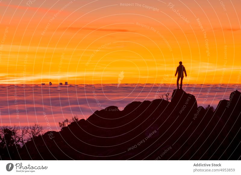 Mann steht auf einem hohen Felsen und betrachtet den Sonnenuntergang Silhouette Wolken Berge u. Gebirge Himmel hoch Natur aktiv extrem Nebel Klippe Top Gipfel
