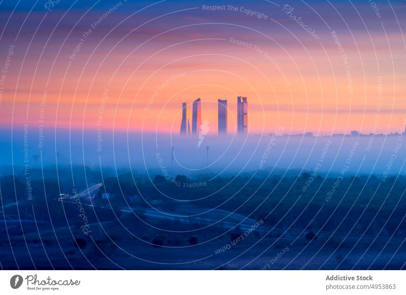 Wolkenkratzer über der nebligen Stadt in der Morgendämmerung Großstadt Turm Sonnenaufgang Architektur Gebäude Stadtbild urban Revier Madrid Spanien Europa