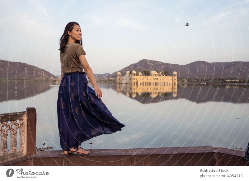 Positive ethnische Frau steht in der Nähe von See und Palast Tourist besuchen Borte Wasser alt Jal Mahal Jaipur Rajasthani Indien Glück asiatisch Lächeln Teich