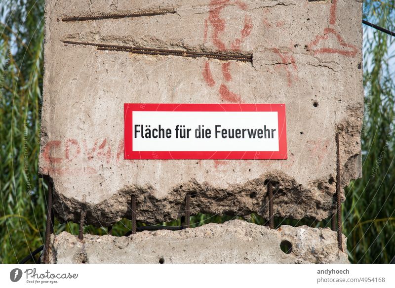 Beschilderung für die Feuerwehr in deutscher Sprache auf einer porösen Oberfläche 112 Unfall Alarm wach Gegend gebrochen abgeplatzt Krise Beschädigte Gefahr
